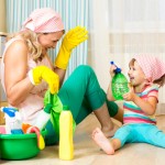 happy mother with kid cleaning room and having fun
