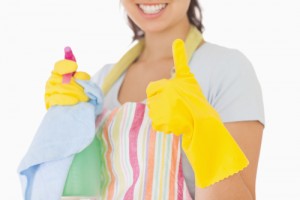 Woman giving thumbs up in rubber gloves holding cleaning products